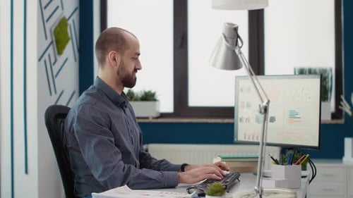 Man Typing at Computer in Modern Office