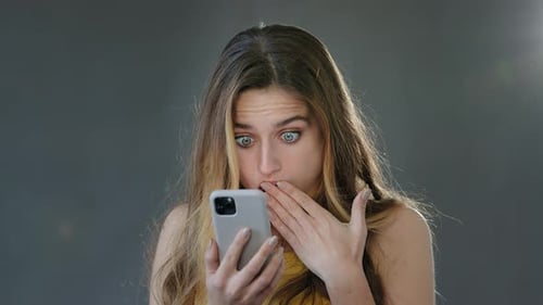 Woman Surprised by News on her Smartphone