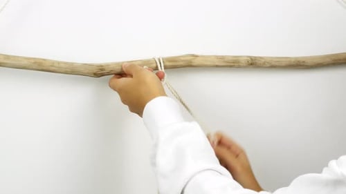 Eine Frau macht Wohnkultur im Boho-Stil. Frau macht handgemachtes Dekor webt Makramee