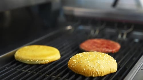 Cooking burgers at restaurant. Close up of chief cooking tasty burger at restaurant