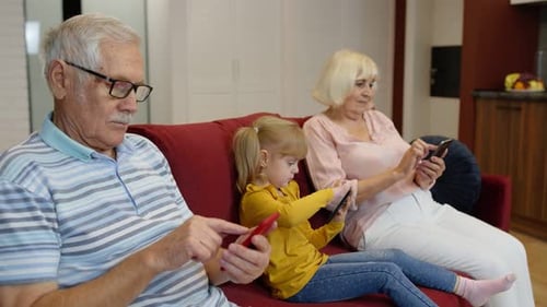 Grandparents and Child Using Technology on Couch