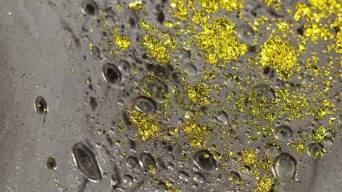 Makro-Nahaufnahme von goldenem nassem Glitter. Goldener Raum-Hintergrund mit glitzernden Partikeln
.