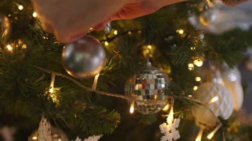Decorating Christmas Tree with Silver Bauble Ornament
