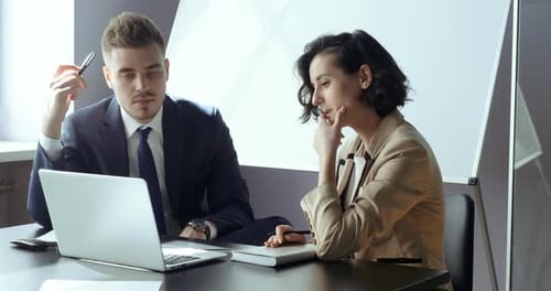 Man and Woman Working on Laptop in Office