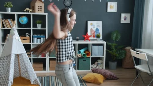 Girl Dances with Headphones in Playroom