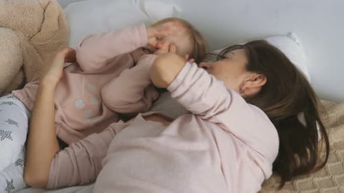 Happy Young Girl Plays With Adult on Bed