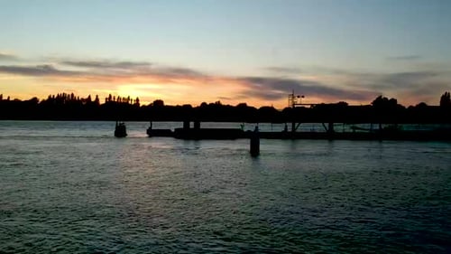 Silhouette de quai de rivière dans la lumière du crépuscule, retrait lent