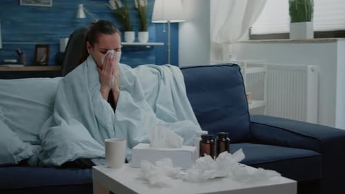 Woman Covered in Blanket with Cold at Home