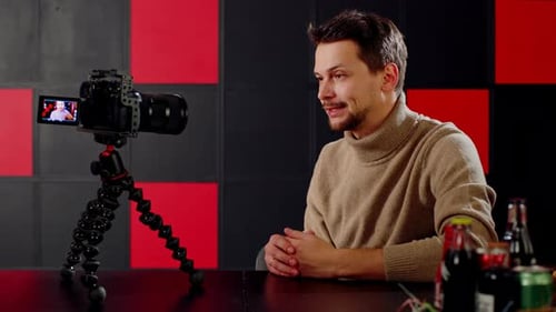 Man Blogger n a Studio Tells Something to His Viewers and Subscribers on Camera