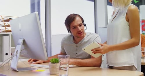 Führungskräfte interagieren bei der Arbeit an Computer und digitalem Tablet 4k