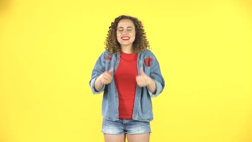 Young Woman Giving Thumbs Up on Yellow Background