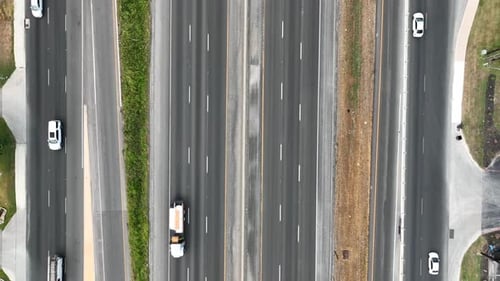 Overhead shot of busy multiple-lane highways and merging vehicles in America. Transportation and tru