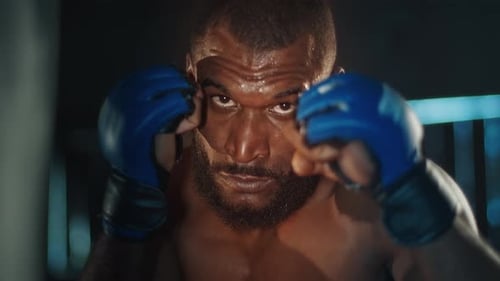 Male Fighter Works Out in the Dark Gym