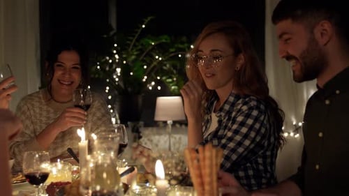 Friends Enjoying a Candlelit Dinner Party at Night