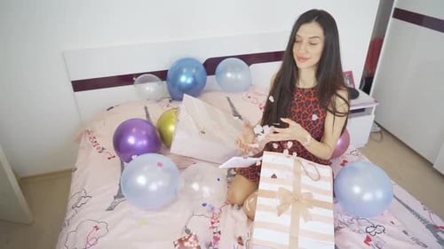Smiling Woman Celebrates Birthday with Gifts and Balloons