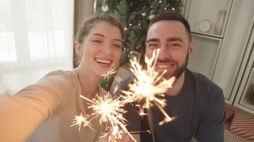 Couple Celebrates Together Holding Sparklers at Home