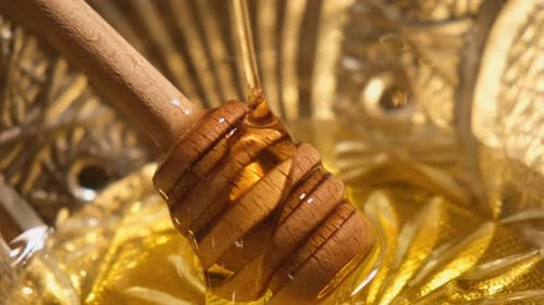 Liquid Honey Pouring on Honey Dipper