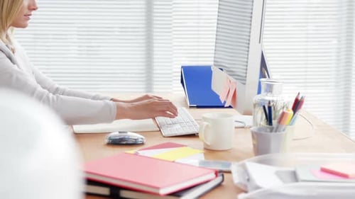 Woman Typing on Keyboard in Modern Office