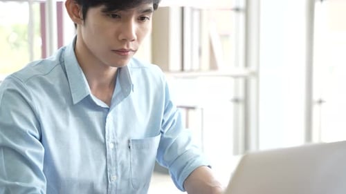 Young Adult Works on Laptop in Bright Setting