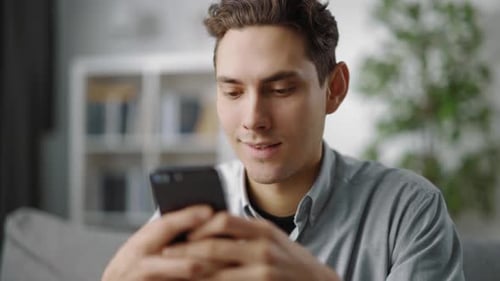 Young Man Using Smartphone at Home