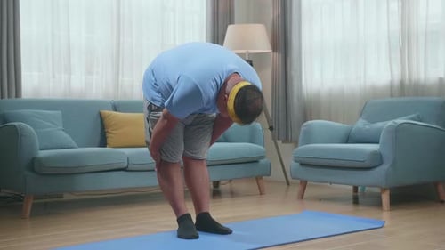 Fat Asian Man On Mat Doing Yoga By Half Standing Forward Bend At Home