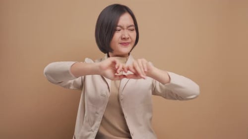 Mulher de negócios asiática estava doente com dores no corpo e estava isolada sobre fundo bege. Vídeo 4K