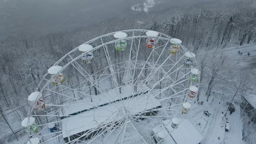 Ferris Wheel on Top of Mount Akhun During a Snowfall