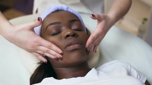Woman Receiving a Relaxing Facial Massage at Spa