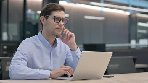 Man at Laptop Has Idea in Office