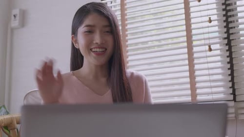 Smiling Young Adult Woman Waving During Video Call