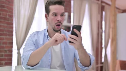Man Reacts to Disappointing News on Phone