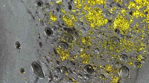 Macro Close Up Shot Of Golden Wet Glitter. Golden Space Glittering Particle Background.