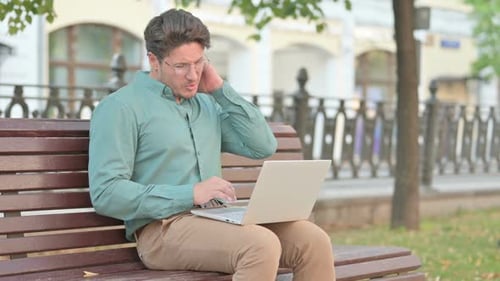 Adult Man Massaging Stiff Neck While Working Outdoors