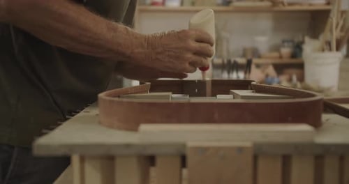 Luthier Aplicando cola em um instrumento