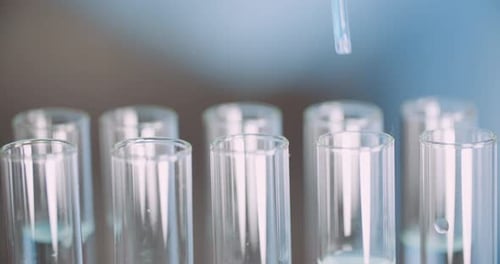 Dropper Adding Blue Liquid to Test Tubes