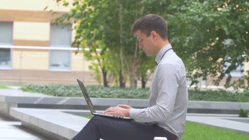 Stilvoller Geschäftsmann arbeitet am Laptop im Freien, Terrasse, Tasse Kaffee