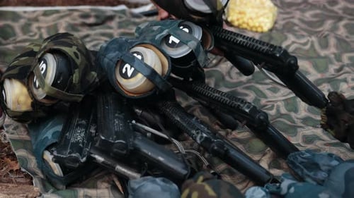 Waffen zum Paintballspielen liegen auf dem Boden