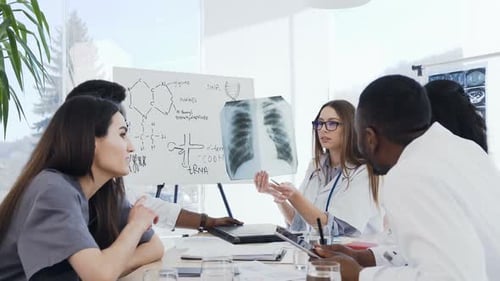 Female Doctor Holding in Hands x-ray Film During Conference in Clinic
