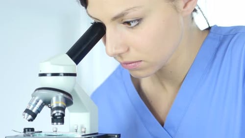 Woman Using Microscope in Science Lab