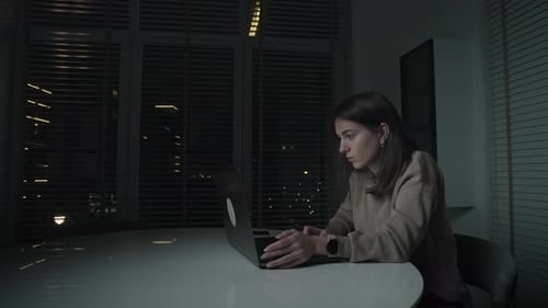 Woman Working on Laptop at Night in Urban Home