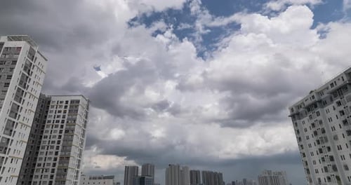 Urban time lapse featuring dramatic tropical storm and rain clouds, high rise apartment buildings, a