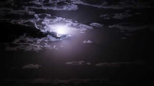 Clouds Obscure Shining Moon in Night Sky