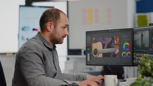 Video Editor Working at Desk in Modern Office