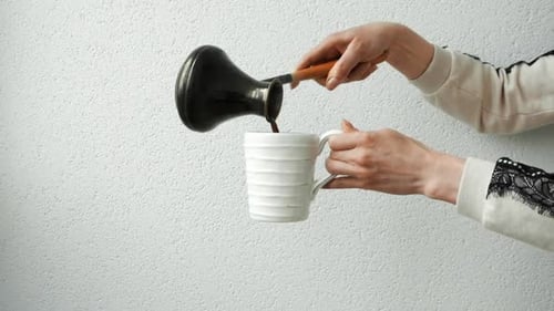 Pouring Fresh Coffee into a White Mug