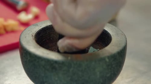 Cook Prepares the Seasoning for the Salad in a Mortar 2