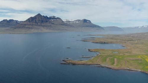 Aerial Panoramic Shot of Sea Bay with High Snow Dusted Mountain Ridge in Background