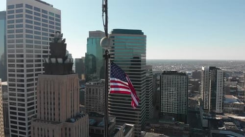 American Flag Waving High Above City Skyscrapers