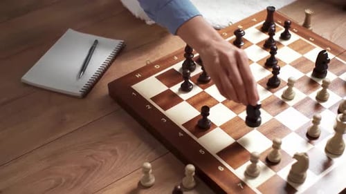 Mãos de mulheres fazem um movimento com uma peça de xadrez em um tabuleiro de xadrez, garota jogando xadrez segurando