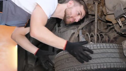 Vertikales Video: Ein professioneller Automechaniker arbeitet unter dem König einer Hebemaschine in einem Auto