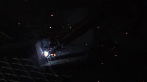 Zeitlupe von Funken, die vom Lichtbogenschweißer fliegen.